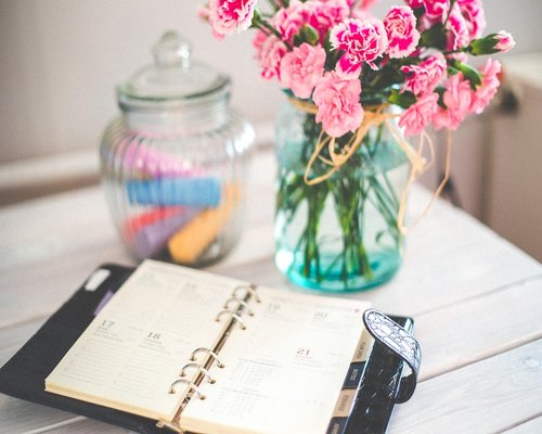 A glass of water and notebook on an office desk